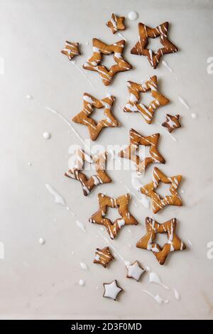 L'étoile de Noël Maison cookies caramel sucre forme avec plus de glaçage blanc en arrière-plan. Mise à plat, l'espace de copie. Noël sucré ou nouvel an cadeau. Banque D'Images