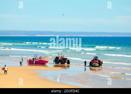 Pêcheurs à Costa da Caparica au Portugal . Les gens sur la plage de l'océan Atlantique. Bateaux de pêche et tracteurs sur la rive Banque D'Images