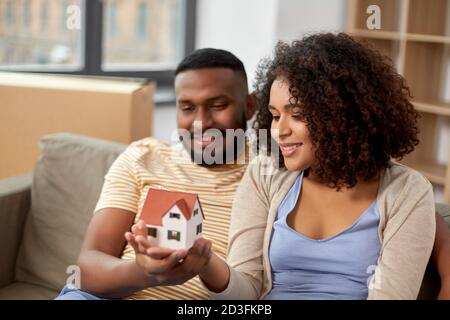 couple heureux avec le modèle de maison se déplaçant à la nouvelle maison Banque D'Images