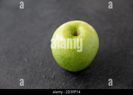 pomme verte mûre sur fond de pierre d'ardoise Banque D'Images