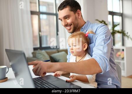 père travaillant avec bébé fille au bureau à domicile Banque D'Images