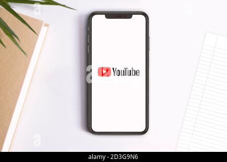 Smartphone affichant le logo youtube sur son écran. Espace de copie vide pour le contenu de l'éditeur. Banque D'Images
