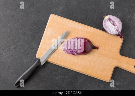 oignon rouge et couteau de cuisine sur la planche à découper Banque D'Images