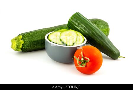 Tranches de concombre vert, de tomate rouge et de courgettes vertes isolées sur fond blanc. Une alimentation saine. Banque D'Images