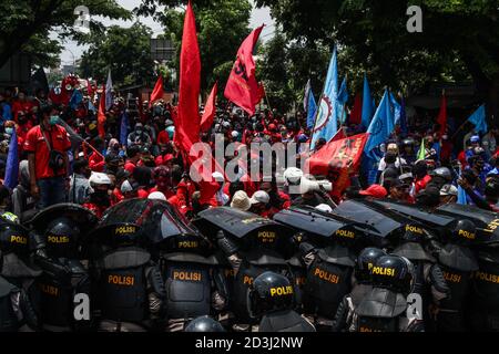 Cileunyi, Indonésie. 08 octobre 2020. Des policiers anti-émeutes tiennent leurs boucliers pendant la manifestation à Cileunyi. Les syndicats ouvriers et les syndicats étudiants sont descendus dans la rue, bloquant la route nationale Bandung-Garut-Tasikmalaya jusqu'à la porte de péage de Cileunyi. Ils protestent contre la nouvelle loi sur la création d'emplois qui a été adoptée lundi par le Parlement. Crédit : SOPA Images Limited/Alamy Live News Banque D'Images