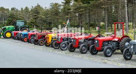 Une gamme de tracteurs, neufs et anciens, au parc automobile de Newborough Beach, Anglesey, pays de Galles Banque D'Images