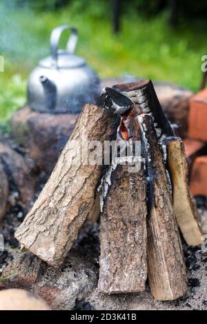 Bouilloire de pique-nique extérieure avec une touche vintage près d'un feu de camp. Cuisine à l'extérieur, feu de camp. Banque D'Images