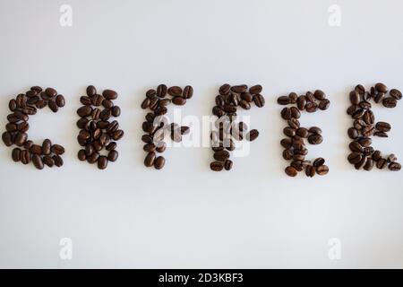 Mot de café, texte fait de grains de café torréfiés isolés sur fond blanc. Banque D'Images