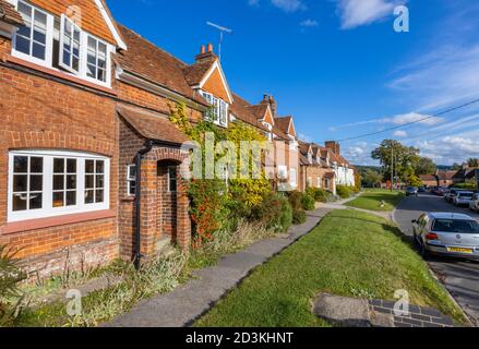 Vue sur les maisons et les chalets en terrasse typiques de briques rouges dans la grande rue principale de Great Bedwyn, un village dans l'est du Wiltshire, dans le sud de l'Angleterre Banque D'Images