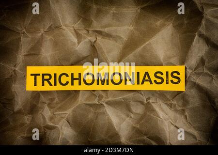 Trichomoniase. Morceau de papier jaune avec le mot trichomoniase. Gros plan. Banque D'Images