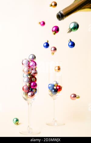 Boules de Noël versées à partir d'une bouteille de champagne, image de concept créative pour noël, thème des fêtes Banque D'Images