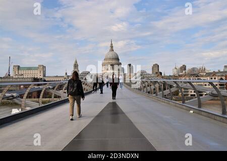 Une femme avec un masque facial protecteur traverse le pont du Millénaire avec la cathédrale St Paul en arrière-plan, Londres 2020 Banque D'Images