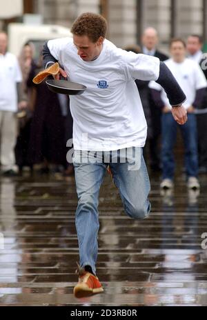 A competitor takes part in an annual Shrove Tuesday pancake race organised by the All Hallows Church near the Tower of London, February 24, 2004. REUTERS/David Bebber  BEB/MD