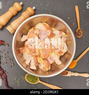 ailes de poulet marinées dans un bol en métal sur la table Banque D'Images