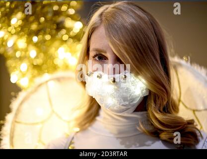 Berlin, Allemagne. 08 octobre 2020. Une jeune femme habillée d'ange porte un protecteur de bouche et de nez brillant en marge de la conférence de presse pour l'événement "jardin de Noël Berlin 2020" dans le jardin botanique de Berlin. De 20.11.2020 à 10.01.2021, les installations lumineuses seront exposées au public lors d'une promenade circulaire. Credit: Britta Pedersen/dpa-Zentralbild/ZB/dpa/Alay Live News Banque D'Images