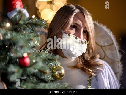 Berlin, Allemagne. 08 octobre 2020. Une jeune femme habillée d'ange porte un protecteur de bouche et de nez brillant en marge de la conférence de presse pour l'événement "jardin de Noël Berlin 2020" dans le jardin botanique de Berlin. De 20.11.2020 à 10.01.2021, les installations lumineuses seront exposées au public lors d'une promenade circulaire. Credit: Britta Pedersen/dpa-Zentralbild/ZB/dpa/Alay Live News Banque D'Images
