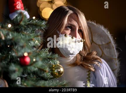 Berlin, Allemagne. 08 octobre 2020. Une jeune femme habillée d'ange porte un protecteur de bouche et de nez brillant en marge de la conférence de presse pour l'événement "jardin de Noël Berlin 2020" dans le jardin botanique de Berlin. De 20.11.2020 à 10.01.2021, les installations lumineuses seront exposées au public lors d'une promenade circulaire. Credit: Britta Pedersen/dpa-Zentralbild/ZB/dpa/Alay Live News Banque D'Images