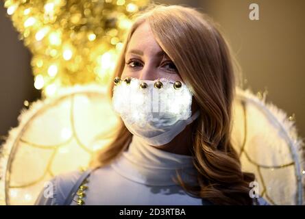 Berlin, Allemagne. 08 octobre 2020. Une jeune femme habillée d'ange porte un protecteur de bouche et de nez brillant en marge de la conférence de presse pour l'événement "jardin de Noël Berlin 2020" dans le jardin botanique de Berlin. De 20.11.2020 à 10.01.2021, les installations lumineuses seront exposées au public lors d'une promenade circulaire. Credit: Britta Pedersen/dpa-Zentralbild/ZB/dpa/Alay Live News Banque D'Images