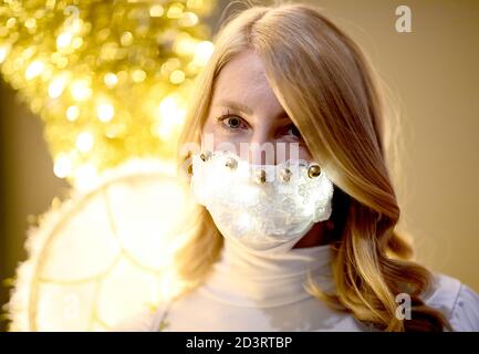 Berlin, Allemagne. 08 octobre 2020. Une jeune femme habillée d'ange porte un protecteur de bouche et de nez brillant en marge de la conférence de presse pour l'événement "jardin de Noël Berlin 2020" dans le jardin botanique de Berlin. De 20.11.2020 à 10.01.2021, les installations lumineuses seront exposées au public lors d'une promenade circulaire. Credit: Britta Pedersen/dpa-Zentralbild/ZB/dpa/Alay Live News Banque D'Images