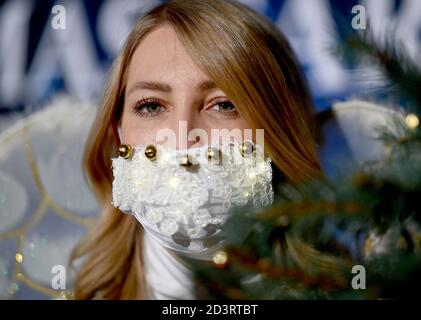 Berlin, Allemagne. 08 octobre 2020. Une jeune femme habillée d'ange porte un protecteur de bouche et de nez brillant en marge de la conférence de presse pour l'événement "jardin de Noël Berlin 2020" dans le jardin botanique de Berlin. De 20.11.2020 à 10.01.2021, les installations lumineuses seront exposées au public lors d'une promenade circulaire. Credit: Britta Pedersen/dpa-Zentralbild/ZB/dpa/Alay Live News Banque D'Images