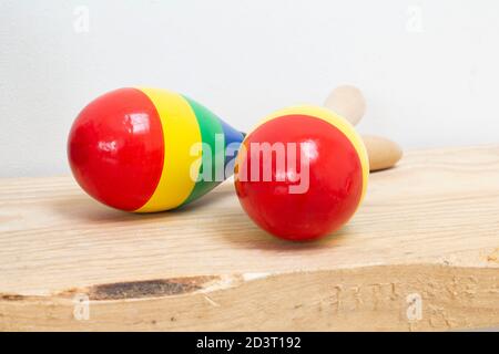 Maracas mexicain en bois coloré sur étagère en bois et fond blanc, bel instrument Banque D'Images