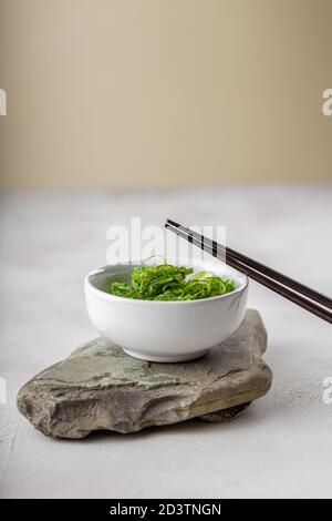 Photo croppée de salade d'algues wakame vertes avec baguette au le restaurant Banque D'Images