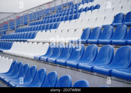 Des gradins dans un stade sportif. Sièges blancs et bleus dans un grand stade de rue. Banque D'Images