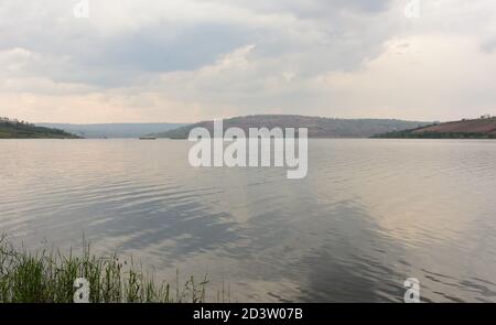 Lac Muhazi eau et petites collines sur les rives et le ciel bleu avec des nuages Banque D'Images