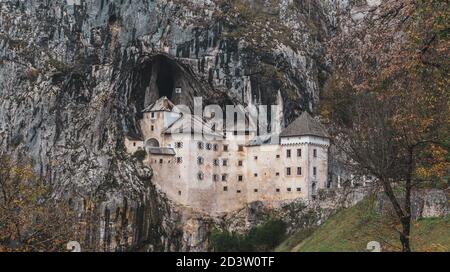 Predjama/ Slovénie-11 octobre 2018 : magnifique château en pierre construit en face de l'entrée de la grotte, protégé par une falaise abrupte et inaccessible Banque D'Images