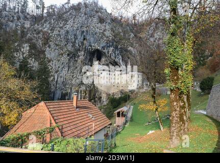 Predjama/ Slovénie-11 octobre 2018 : magnifique château en pierre construit en face de l'entrée de la grotte, protégé par une falaise abrupte et inaccessible Banque D'Images