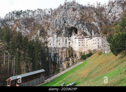 Predjama/ Slovénie-11 octobre 2018 : magnifique château en pierre construit en face de l'entrée de la grotte, protégé par une falaise abrupte et inaccessible Banque D'Images