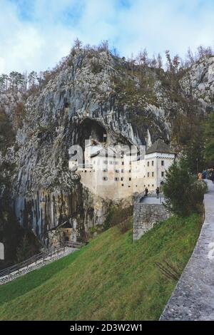 Predjama/ Slovénie-11 octobre 2018 : magnifique château en pierre construit en face de l'entrée de la grotte, protégé par une falaise abrupte et inaccessible Banque D'Images