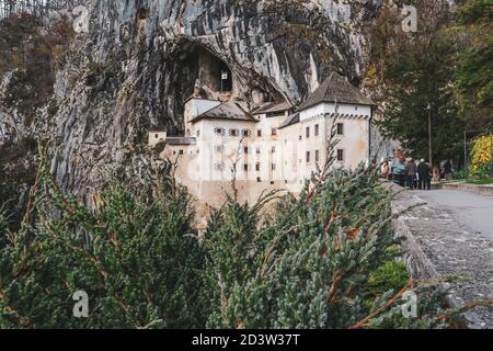 Predjama/ Slovénie-11 octobre 2018 : magnifique château en pierre construit en face de l'entrée de la grotte, protégé par une falaise abrupte et inaccessible Banque D'Images