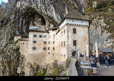 Predjama/ Slovénie-11 octobre 2018 : magnifique château en pierre construit en face de l'entrée de la grotte, protégé par une falaise abrupte et inaccessible Banque D'Images