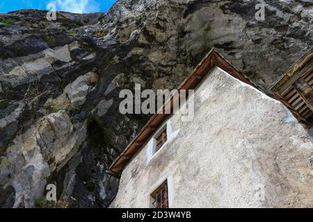 Predjama/ Slovénie-11 octobre 2018 : magnifique château en pierre construit en face de l'entrée de la grotte, protégé par une falaise abrupte et inaccessible Banque D'Images