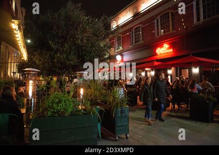 Clapham, Londres, Royaume-Uni, 8 octobre 2020 : les repas en plein air restent populaires à Londres malgré la hausse des taux de coronavirus dans la capitale. Sur la rue piétonne de Venn, à Clapham, les tables étaient remplies et les gens passaient en chemin jusqu'à la dernière nuit du cinéma Picturehouse, qui fait partie de la chaîne Cineworld, qui était ouvert avant le palantage jusqu'en mars 2021. Anna Watson/Alay Live News Banque D'Images