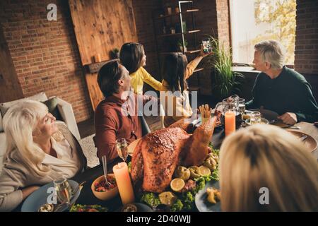 Photo de la famille complète de la mère femme tenir le téléphone prendre portrait caméra petite fille mari grands-parents traditionnel dîner grande table turquie Banque D'Images