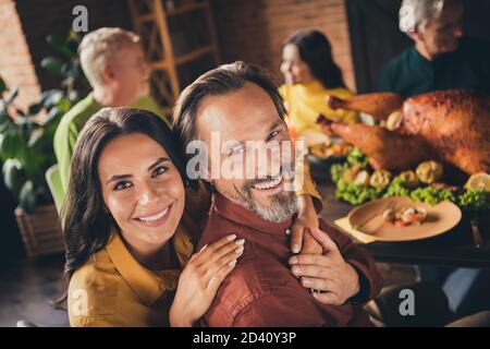 Gros plan photo de la famille entière rassemblement de mari barbu épouse câlin sourire tenir les mains terminer manger repas s'asseoir servi dîner grande table turquie Banque D'Images