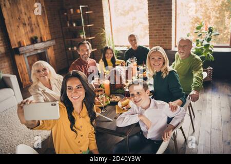 Photo de la famille complète rassemblant huit personnes femme mère tenir téléphone faire tourner selfie harmonie paisible jour servi dîner grand tableau turquie Banque D'Images