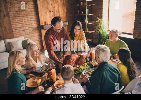 Photo de la famille complète huit personnes rassemblant un père en soigne femme tenir debout couverts farcis dinde rôtie harmony bavarder servi dîner grande table Banque D'Images