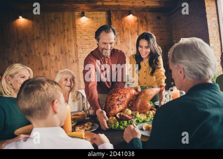 Photo de la famille complète s'asseoir barbu père apporter bourré pommes de dinde cuites au citron, plats préparés pour commencer le dîner génération de grandes tables Banque D'Images