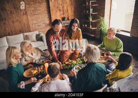 Photo de la famille complète huit personnes rassemblant la femme du père barbu apportez la garniture de début de repas de dinde farcie cuite grande table pour le dîner Banque D'Images