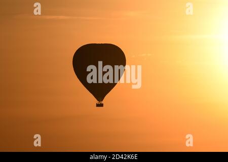 Montgolfière silhouettée profitant du coucher de soleil de Serengeti au Kenya Banque D'Images