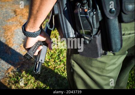 Newport News, Virginie, États-Unis. 8 octobre 2020. Un Ranger de Newport News Park détient le pistolet Glok de Mike Dunn lors d'un rallye de campagne pour le candidat du vice-président libertaire Jeremy 'brochet' Cohen à Huntington Park à Newport News, va, le 8 octobre 2020. Dunn a été arrêté pour intrusion pour avoir refusé de quitter le parc qui est la propriété de la ville. Crédit : John C. Clark/ZUMA Wire/Alay Live News Banque D'Images