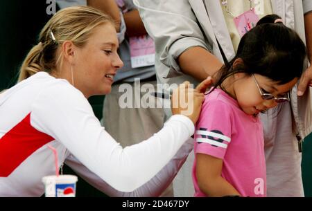 Russia's Wimbledon champion Maria Sharapova signs a South Korean girl's t-shirt in Seoul September 29, 2004. Sharapova will have the second round of the Hansol Korea Open Tennis Championshipson on Thursday. REUTERS/Kim Kyung-Hoon  KKH/FA