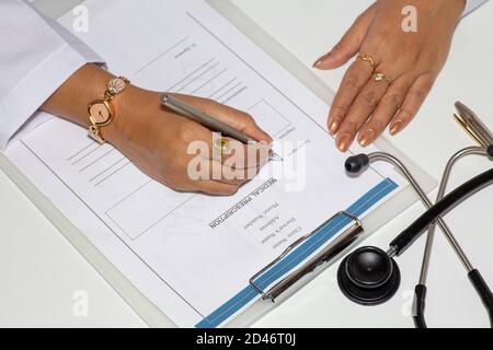 Une femme médecin rédigeant un formulaire de prescription médicale avec des flacons de vaccin sur la table Banque D'Images