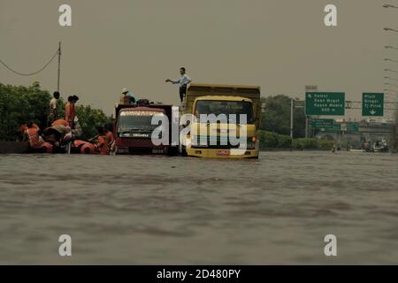 Les travailleurs de la ville de Jakarta chargés du contrôle des crues et de la gestion de l'eau travaillent avec l'agence indonésienne de recherche et de sauvetage (Basarnas) pour atténuer les crues sur la route à péage de l'aéroport de Jakarta. Banque D'Images