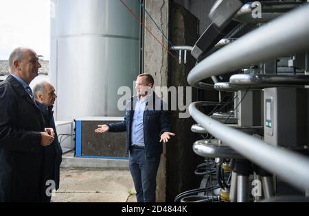 07 octobre 2020, Brandenburg, Kloster Lehnin/OT Netzen: Dietmar Woidke (l, SPD), ministre-président de Brandenburg, et Nicholas O'Brien (M), ambassadeur d'Irlande, visitent l'Agrargesellschaft Emster-Land mbH lors de sa visite inaugurale à Brandenburg et sont présentés le salon de traite par Paul Costello (r), l'un des directeurs généraux. La ferme a été reprise par la famille irlandaise Costello en 2014. Depuis deux ans, l'Agrigesellschaft est convertie au système irlandais de pâturage sans gestion de grange. De cette façon, les vaches de la race Jersey/Holstein Friesian restent sur les pâturages toute l'année. Le Banque D'Images