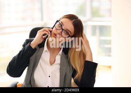 Jeune femme d'affaires souriante et heureuse travaillant au bureau Banque D'Images