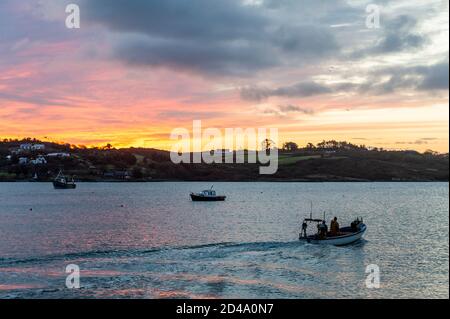 Schull, West Cork, Irlande. 9 octobre 2020. Un pêcheur pilote son bateau pour un voyage pour tirer ses pots de crabe dans Schull Harbour alors que le soleil se lève sur l'eau. Crédit : AG News/Alay Live News Banque D'Images